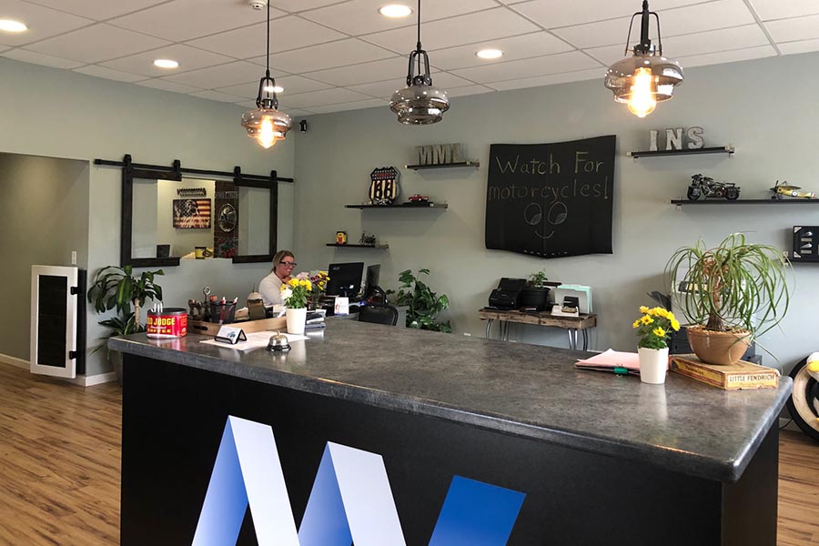 About Our Agency - Interior of the Office of MML Insurance, a Welcoming Desk, Vintage Industrial Lighting, a Chalkboard Sign and Shelves of Decor